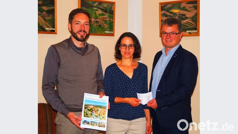 Bürgermeister Martin Birner (rechts) übergab den Scheck für das Baukindergeld an Jörg und Elisabeth Maderer Bild: agr