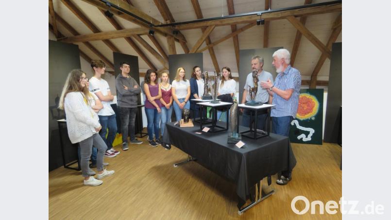 Künstler Toni Eichinger und Kunstpädagoge Helmut Völkl (von rechts) erklären den Schülern anhand der Skulpturen und Gemälde unterschiedliche Techniken. Bild: ubb