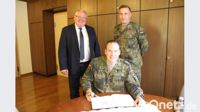 Mit einer Widmung und einem Abschiedsgruß trug sich Obersleutnant Las Obst (stehend rechts) in das Gästebuch ein und Oberstleutnant Michael Zweers merkte im Gästebuch an, dass er sich auf seine neue Aufgabe in Oberviechtach freue. Beiden wünschte Bürgermeister Heinz Weigl (stehend links) für ihre neuen Aufgaben die nötige Portion „Soldatenglück“. Bild: frd