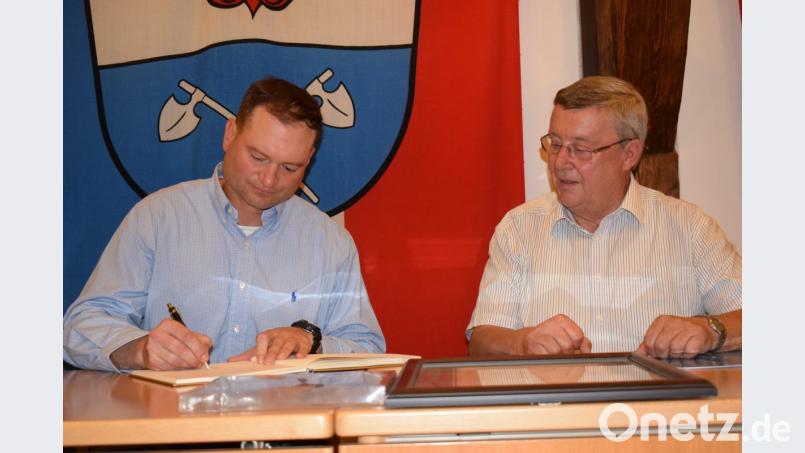 Charles W. Knoll (links) trägt sich ins goldene Buch der Marktgemeinde ein. Wie Bürgermeister Hans Koch (rechts) bekundet er den Willen, die Kontakte zwischen Königstein und der US-Army weiter zu pflegen. Bild: wku