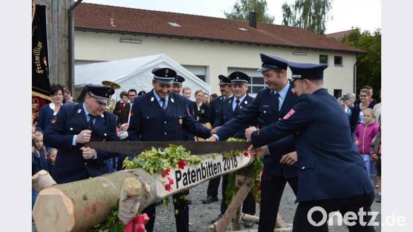 Vorsitzender Josef Schmid (links) und Kommandant Christian Winnerl (rechts) bewältigten die erste Herausforderung mit Bravour. Der Baumstamm hielt den Sägekünsten nicht lange stand. Bild: bej