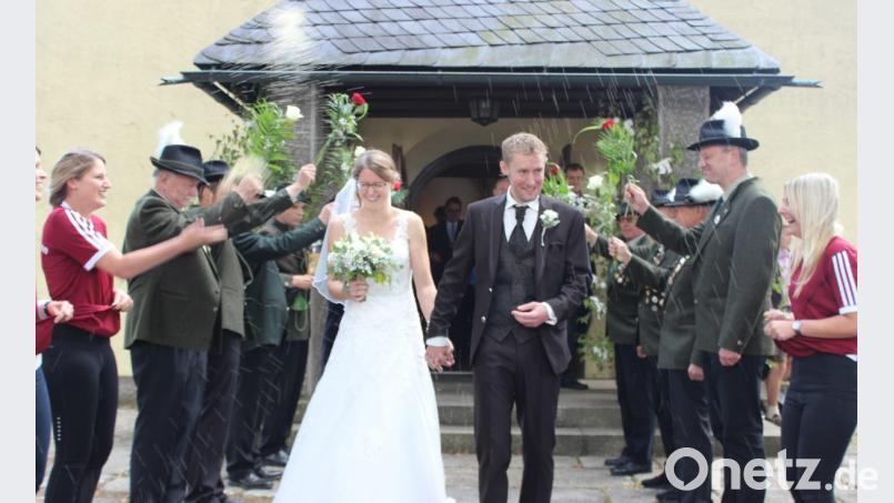 Nina und Andras Fuchs schreiten nach der Trauung durch ein großes Ehrenspalier. Bild: exb