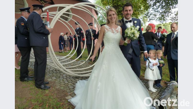 Sabrina Meier und Sebastian Schneider mussten nach dem Ja-Wort in der Jakobi-Kirche eine Saugleitung der FFW Kühried kuppeln. Danach wartete noch ein Baumstamm der Gonfeiaschta Kirwaleid zum Durchsägen. Bild: Portner
