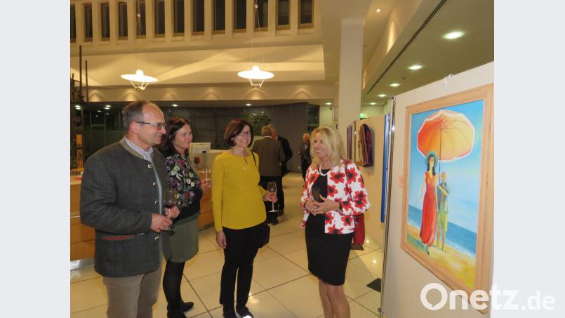 Smaltalk vor bestens bestückten Stellwänden: KV-Vorsitzende Petra Schicker (re.) erklärt einigen Gästen ihr Gemälde "Pablo und Francoise". Sie sei die einzige der vielen Frauen von Picasso, die ihn selbstbewusst eines Tages einfach wieder verlassen habe, so Schickers Erklärung zu ihrem Motiv. Bild: ubb