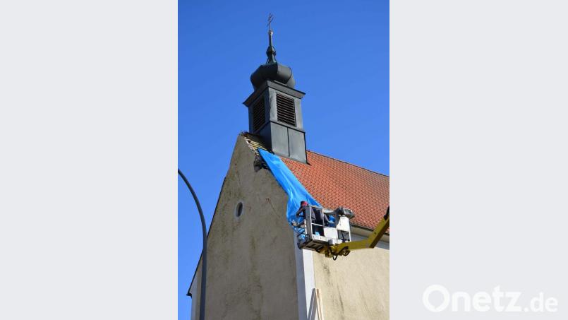 Eine Dachdeckerfirma beseitigt die Schäden an der Dorfkirche in Altzirkendorf, zumindest soweit, dass kein Wasser in das Kirchenschiff eindringen kann. Bild: ü