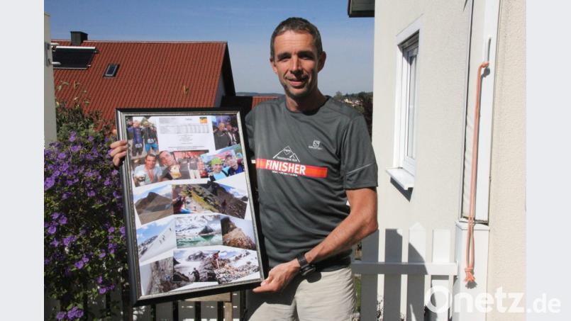 Der 47-jährige Stephan Meier trägt das Finisher-Shirt und zeigt eine Foto-Collage mit Impressionen des Transalpine-Run, die seine Schwester Barbara Spickenreither gemacht hat. Bild: Mardanow
