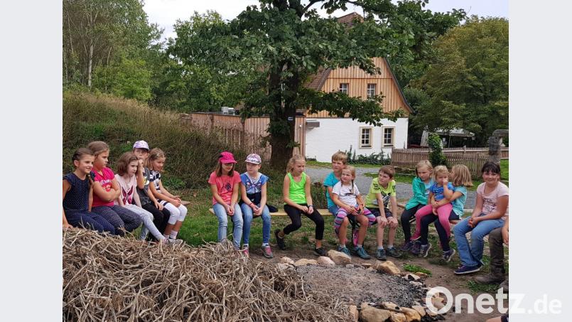 Die Kinder warten, bis das Kartoffelkraut für das Feuer aufgeschichtet werden kann. Bild: hai