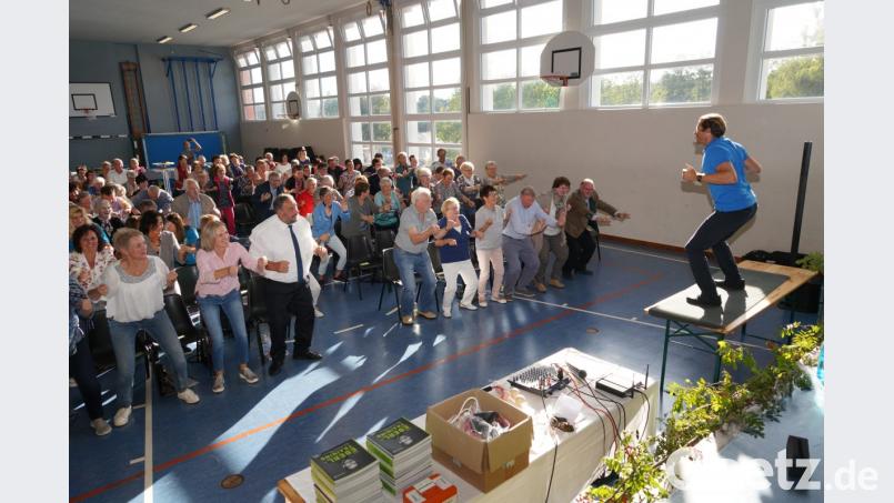 Gefordert sind die Zuhörer bei der Auftaktveranstaltung von NEUN2727. Selbst Bürgermeister Josef Beimler geht vor dem Gesundheitscoach in die Knie. Bild: fvo