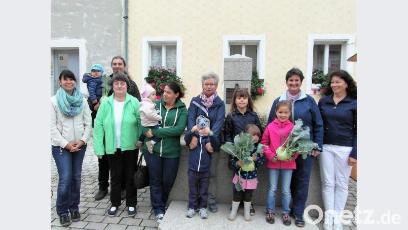 An die Kinder mit den größten Kohlrabi verteilt Elisabeth Reger (vorne, Zweite von links), Vorsitzende des Obst- und Gartenbauvereins, Pizza-Gutscheine. Bild: hl