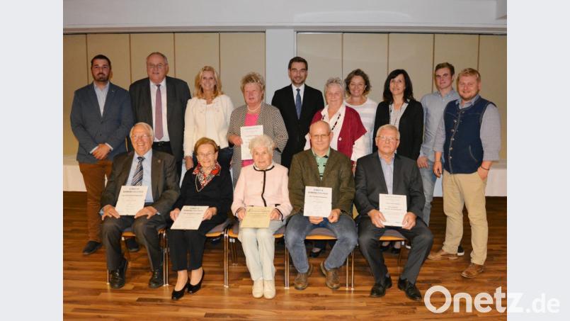 CSU-Ortsvorsitzender Dominik Baschnagel (rechts) zeichnet zusammen mit FU-Ortsvorsitzender Elisabeth Weiß (stehend, fünfte von rechts) langjährige Mitglieder mit Urkunden und Präsenten aus. Bild: Schmola, Werner