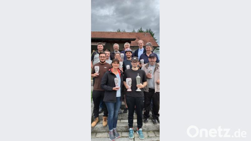 Fabian Kosub vom Team Wuaschba I (vorne, Mitte) präsentiert den Sieger- und Wanderpokal. Mit im Bild Vorsitzender Stefan Hagn (hinten links) und Bürgermeister Konrad Kiener (hinten rechts). Bild: krs