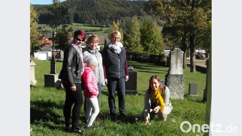 Anja Putzer (rechts) zeigt den Teilnehmern unter anderem im Alten Friedhof, welche Wildpflanzen dort wachsen und wie sie im Hinblick auf Nahrung und Gesundheit angewandt werden können. Bild: hl