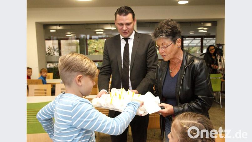 Annette Erös und Landrat Thomas Ebeling verteilten an die Kinder der Kreuzbergschule Fingerfood aus fairem Handel. Bild: Hirsch