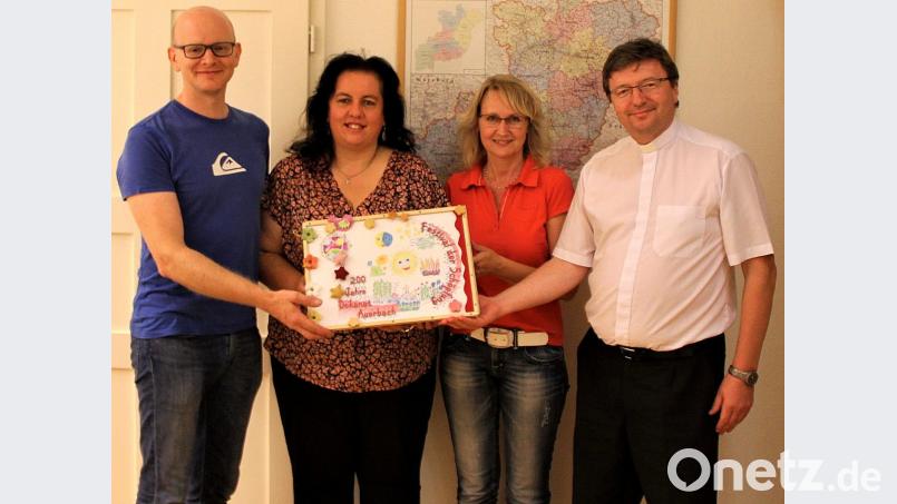 Das Fotobuch hält Eindrücke des Kindergarten-Projekts fest. Von links Konstantin Lindner, Dekanatsratsvorsitzende Sonja Schwemmer, Schriftführerin Regina Schrembs und Dekan Pater Markus Flasinski. Bild: sck