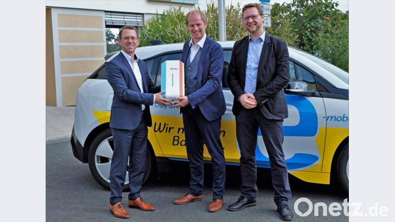 Dr. Andre Zorger und Wolfgang Dumm (von links) von der Abteilung Kommunen und Kooperation des Bayernwerks übergeben Bürgermeister Konrad Kiener (Mitte) die Wallbox. Bild: twi