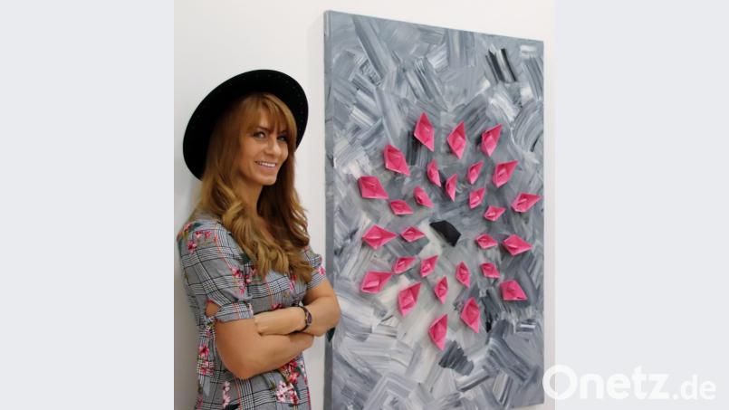 Die Schwandorfer Malerin Nicole Y. Matschiner vor einem ihrer Werke, die im „Kunst-Lokal“ an der Friedrich-Ebert-Straße in Schwandorf ausgestellt sind. Dieses Bild ist eines aus der Serie „Paperboats“ (Papierschiffchen). Bild: Thomas Dobler