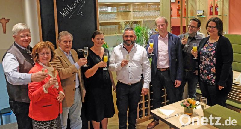 Veronika und Andrea Tabuso (Vierte und Fünfter von rechts) stießen mit Bürgermeister Konrad Kiener (Dritter von rechts), Schreiner und Gestalter Florian Danzl (Zweiter von rechts) sowie Judith Kiener (rechts) sowie weiteren Gästen auf die Neueröffnung an. Bild: twi