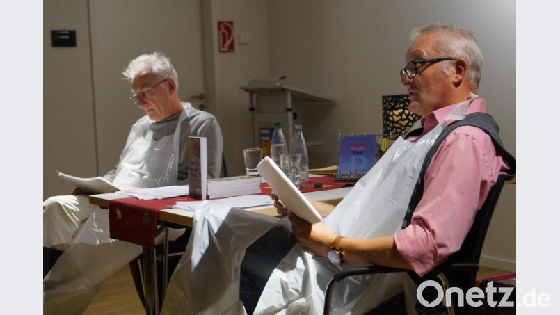 Einen Kriminalroman über allzu Menschliches stellen Autor Thomas Bäumler (rechts) und Wolfgang Herzer vom Oberpfälzer Kunstverein Weiden in entsprechendem Outfit mit dem Werk "Kain. Abel. Oberpfalz" im Schirmitzer Bürgersaal vor. Bild: du