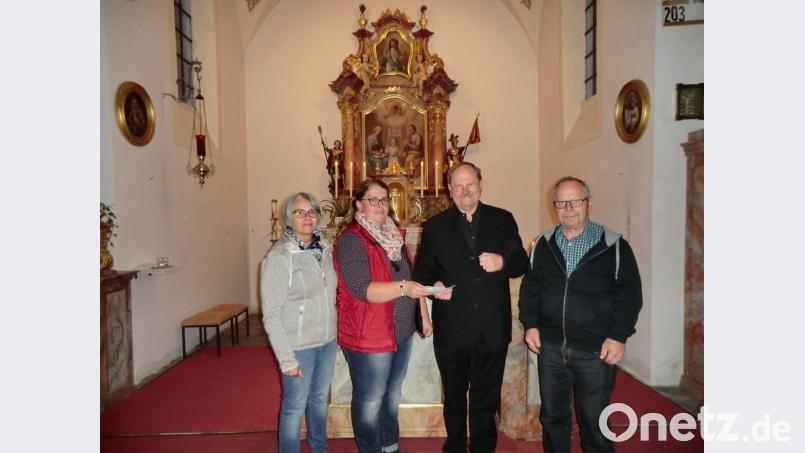 Renate Zaloga und Eva Hoffmann überreichten an Pfarrer Heribert Stretz und Robert Steinkohl (von links) 250 Euro aus dem Verkauf der Kräuterbuschen an Maria Himmelfahrt. Dieses Geld könnte zum Beispiel in die Renovierung des Altars, im Hintergrund des Bildes, fließen. Bild: rpp