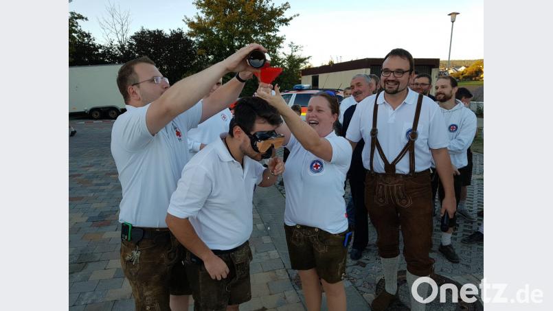 Der stellvertretende Vorsitzende der Wasserwacht Dennis Ponnath (Zweiter von links) musste mit einem Schnorchel ein Flasche Bier leeren, die ihn der taktische Leiter Sebastian Hofmann (links) einflößte Bild: hir