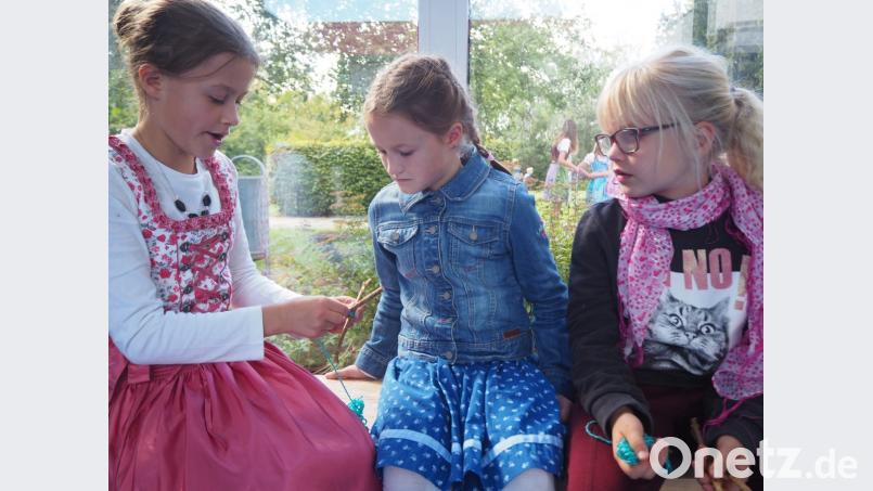 &quot;Schau her, so gehts!&quot; Schnell brachten sich die Kinder gegenseitig bei, wie man aus Ästen und Wolle farbenfrohe Windspiele und Traumfänger zaubern kann. Bild: jpl