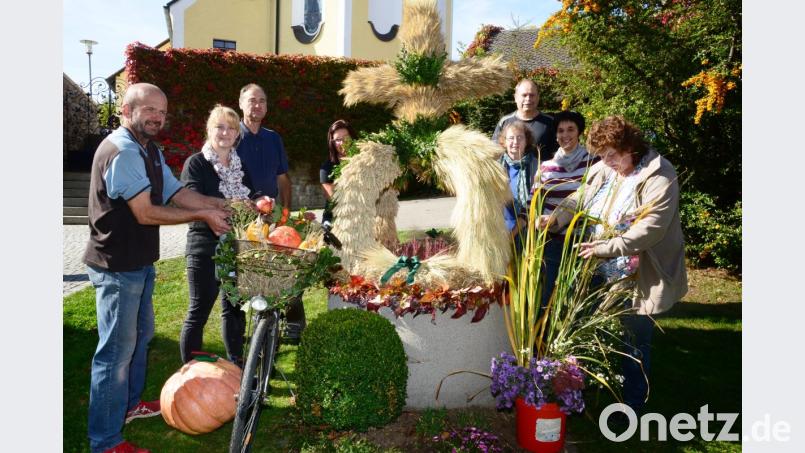 Die Helfer setzen dem Brunnen die Erntedankkrone auf. Bild: bey