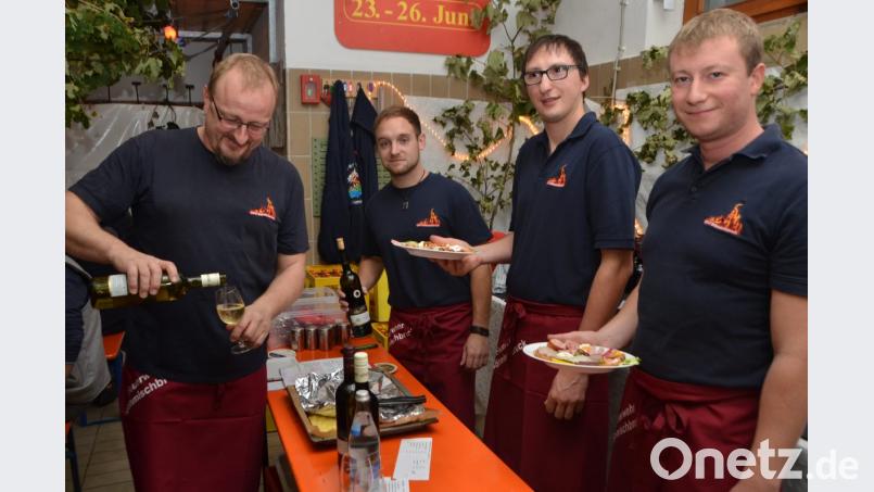 Vorsitzender Reinhard Wiesent, Stellvertreter Richard Seegerer, Michael Meier und Martin Vater (von links) kredenzen mit den vielen Helfern der Feuerwehr den Gästen edle Rebsorten und deftige Brotzeiten. Frohsinn und Geselligkeit kommen dabei nicht zu kurz. Das Feuerwehrhaus ist an diesem Abend zu einer schönen Weinlaube umfunktioniert. Bild: dob