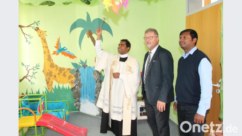 Mit der Unterstützung von Pater Britto (rechts) segnet Pfarrer Julius Johnrose im Beisein von Bürgermeister Johann Maurer die neuen Räume der Krabbelgruppe. Bild: pi