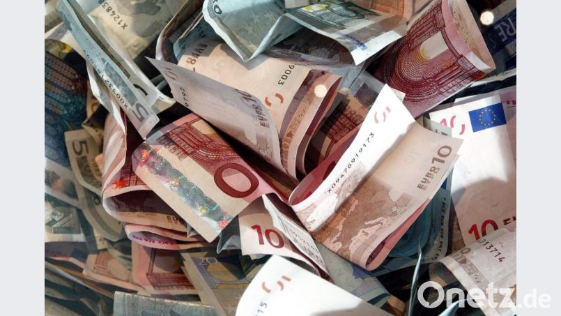 Ein Bauer findet beim Fahren mit seinem Schwader Geld auf der Wiese. Bild: Jens Wolf/dpa