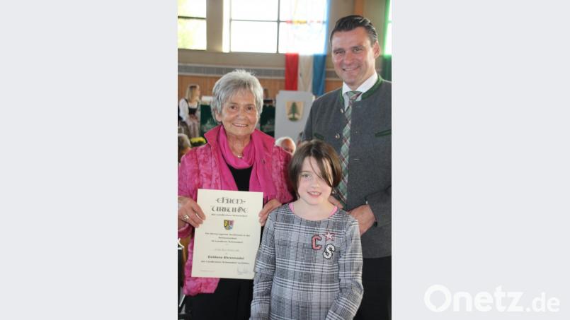 Zusammen mit einer jungen „Assistentin“ überreichte Landrat Thomas Ebeling die Goldene Ehrennadel des Landkreises an Rosina Krafczyk. Mit der Auszeichnung wird der vorbildliche Einsatz für ihre Mitbürger gewürdigt. Bild: frd
