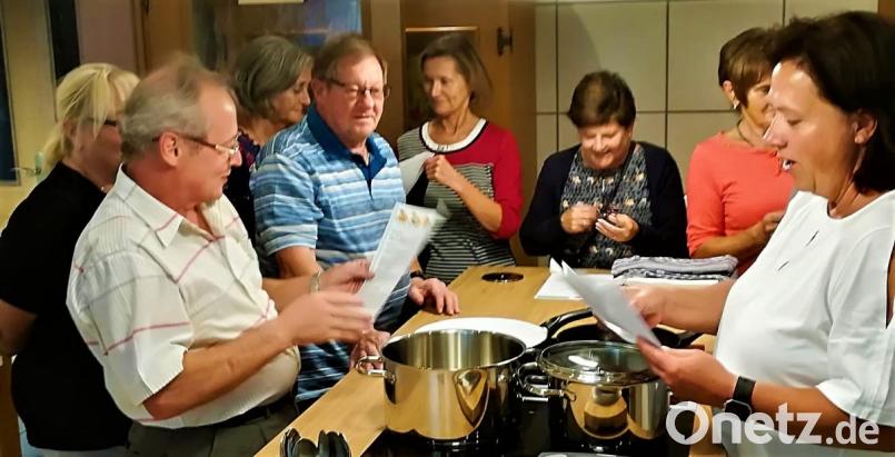 Beim Rezeptstudium waren die Töpfe zwar noch leer, die Teilnehmer haben aber
	schon reichlich Lust auf leckere Schwammerlvarianten. Kursleiterin Rita Frieser 	(rechts) verteilt die Aufgaben, damit jeder alles machen kann. Bild: jml