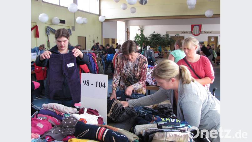 Die Mütter begutachten die gebrauchte Kinderkleidung genau, bevor sie in die Einkaufstüten kommt. Bild: sei