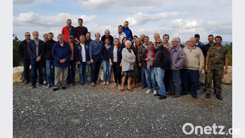 Stabsfeldwebel Norbert Prediger (Zweiter von rechts) hat die Fahrt in den Truppenübungsplatz organisiert. Stabsfeldwebel Christopher Dippel (rechts) zeigt die Sehenswürdigkeiten, darunter der Schwarze Berg, aus dem sich die Gruppe für ein Foto formiert. Bild: knh