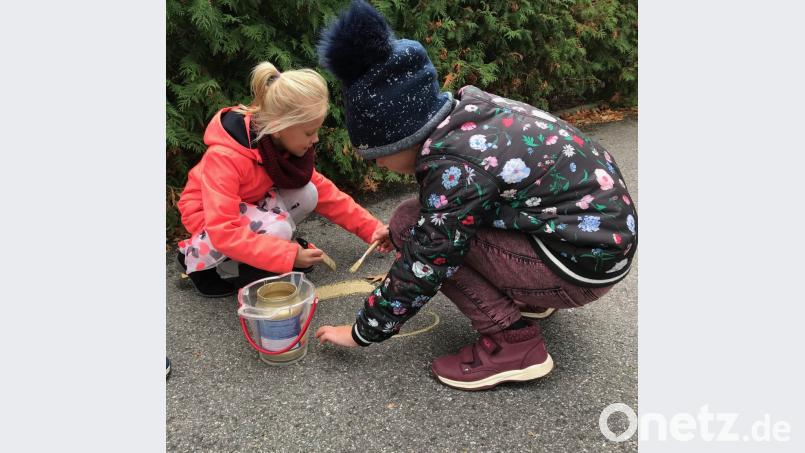 Die eigenen Fußspuren in der &quot;Goldenen Gasse&quot; zu sehen, ist schon etwas Besonderes. Mit Feuereifer malen die Kinder die Fußabdrücke golden aus. Bild: cr