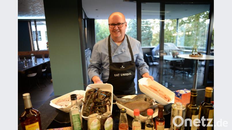 Kursleiter Christian Bücherl präsentiert die Edelfische, Hummer und Meeresfrüchte, die es im Rahmen des Kochevents zubereiten zu galt. Bild: brü