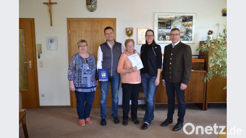 Bürgermeister Hermann Ach (rechts) zeichnet die treuen Feriengäste für den 45. und 25. Aufenthalt aus. Begleitet wurden sie von ihrer Gastgeberin Angelika Forster (links). Bild: gi