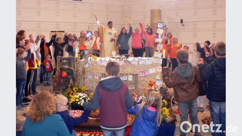 Beim Familiengottesdienst versammeln sich viele Kinder um den Altar, um gemeinsam das Vaterunser zu beten. Pfarrer Augustin Lobo symbolisiert mit Bewegungen der Hände das Gebet. Bild: lep