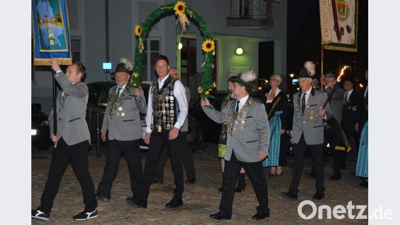Mit einem Fackelzug wird Matthias Wiendl (Mitte) zum Rathaus geleitet. Bild: jr