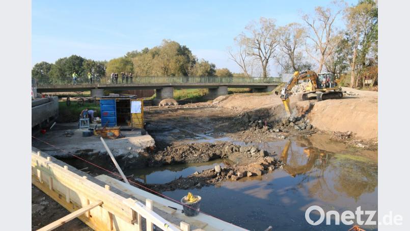 Die alte Wehranlage wurde teilweise abgebrochen und wird nun abgetragen. Hier soll schon bald eine neue Rampe entstehen. Auf der Brücke inspiziert der Bauausschuss die Baustelle. Bild: sne