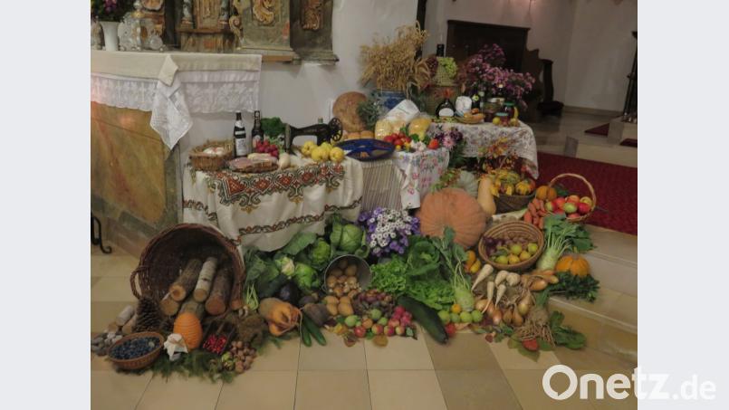Nicht nur Stadtpfarrer Konrad Amschl, sondern auch mehrere Gottesdienstbesucher bewundern den Erntealtar in der Oberndorf Kirche. Bild: jzk