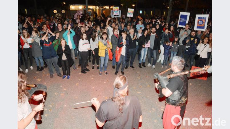 Im blaukarierten Anzug applaudieren die Musiker von „Barbari Bavarii“ zusammen mit andern Protestlern auf der Kundgebung. Im Hintergrund fliegen ein Schweinchen- und ein Herzluftballon. Bild: gsb