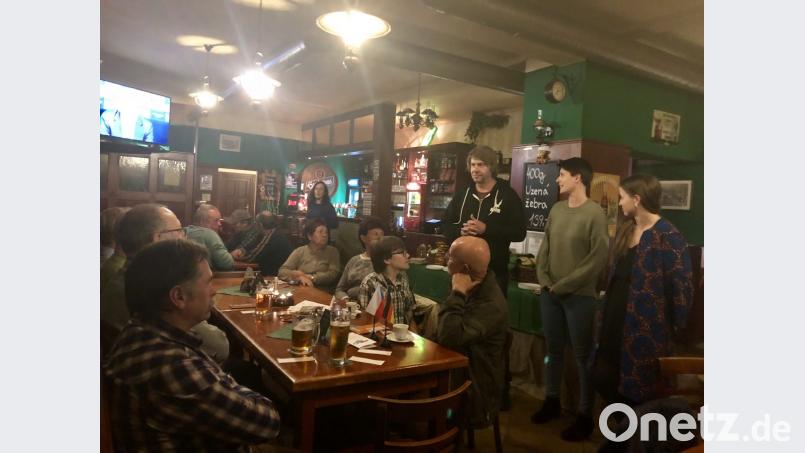 Brauereibesitzer Filip Miller (stehend in der Mitte) macht den Gästen beim Deutsch-Tschechischen Stammtisch seine Braukunst schmackhaft. Die Europäische Freiwillige Marie Eliášová und CeBB-Praktikantin Silvie Burešová (rechts) assistieren beim Ausschenken.. Bild: eib