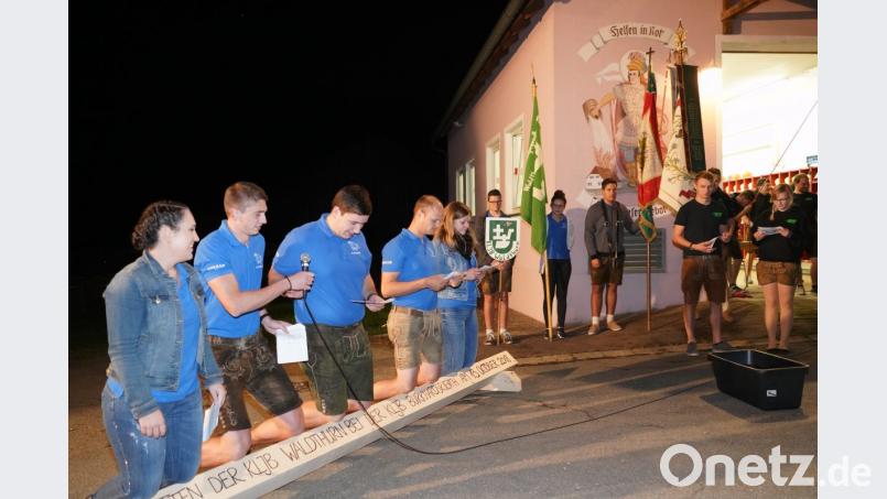 Hannah-Sophia Hornstein, Julian Steiner, Festleiter Felix Griesbach, Johannes Menner und Franziska Wittmann (von links) knien auf dem Jammerbalken. Die Vorsitzenden der KLJB Burkhardsrieth Corinna Ach (rechts) und Daniel Neuber nehmen die Bitte der Waldthurner zur Übernahme der Ehrenpatenschaft entgegen. Bild: fvo