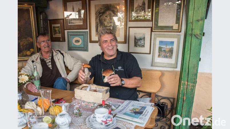 Fritz Seyferth (rechts) in seiner Laube in Weiher, die mit Erinnerungen an seine Münchener Zeit dekoriert ist. Gerade hat er ein Körberl Pilze geschenkt bekommen. Bild: chl