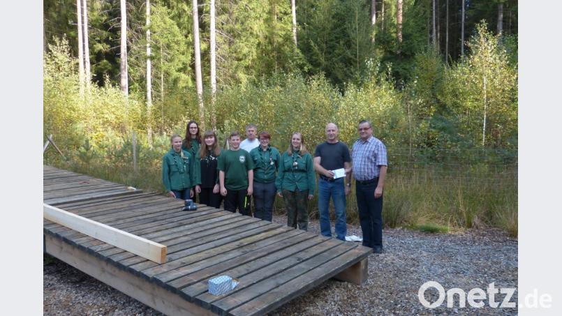 Als Handwerker betätigt sich die Waldjugend mit Horstleiter Walter Seltmann (Zweiter von rechts) an der Spitze: Die Gruppe repariert die Wippe auf dem Walderlebnispfad. Dieter Kies (rechts) honoriert dies im Namen des Stadtverbands mit einer Spende von 100 Euro. Bild: rn