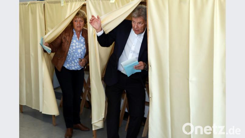 Joachim Hanisch (rechts) kommt aus der Wahlkabine. Als Spitzenkandidat der Freien Wähler auf der Oberpfalz-Liste verteidigte er sicher sein Landtagsmandat. Bild: Götz