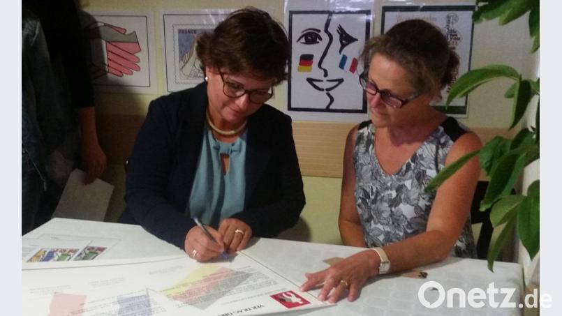 Schulleiterin Irene Sebald (links) und Schulleiterin Patricia Morin (rechts) unterschreiben die Partnerschaftsurkunde. Bild: exb
