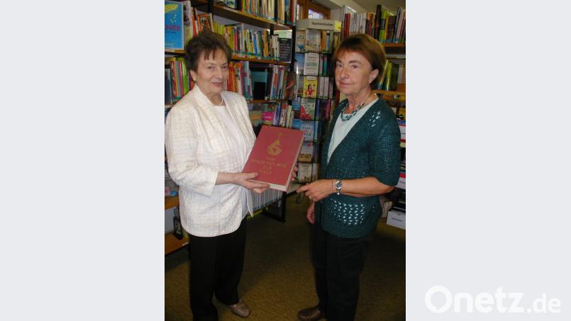 Beim kleinen Empfang in der Bücherei
Leiterin Selma Markhof, rechts, und Namensgeberin des „Bücherstadls“ Marianne Specht zeigen das allererste Buch der Pfarrbücherei, "Vom goldenen Rom zur Welt". Es sollte in jeder Familie im Regal stehen. So wünschte es sich der damalige Pfarrer Anton Winkler. Bild: gis
