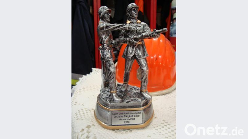 Zweimal wird die Figur der zwei Wehrmänner für 20 Jahre Mitarbeit im Vorstand verliehen: An Kommandant Thorsten Michel und Atemschutzwart Rudi Kummert. Bild: schß