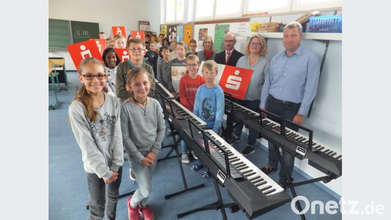Mit den Schulkindern freuen sich Konrektor Stefan Ottmann und Fachlehrerin Regina Rester-Achhammer sowie die Sparkassenmitarbeiter Thomas Bieda und Kathrin Schmidt (von rechts) über die Spende. Bild: ibj